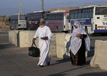 Los palestinos cruzan el puesto de control de Beit Hanoun en su camino hacia el cruce fronterizo de Erez entre Israel y Gaza, en el norte de la Franja de Gaza, el domingo 5 de octubre de 2014. (AP / Adel Hana)