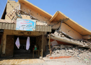Una fotografía tomada el 25 de agosto de 2019 muestra una tienda destruida debajo de un edificio muy dañado en Baiji, una región rica en petróleo devastada por la lucha contra el grupo del Estado Islámico en 2014. (SABAH ARAR / AFP)