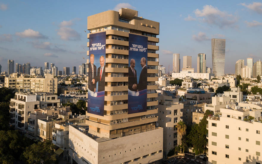 Carteles de la campaña electoral en el edificio de la sede del partido Likud en Tel Aviv que muestran al primer ministro Benjamin Netanyahu dándose la mano con el presidente ruso Vladimir Putin y el presidente de los Estados Unidos, Donald Trump, el 28 de julio de 2019. (Adam Shouldman / Flash90)