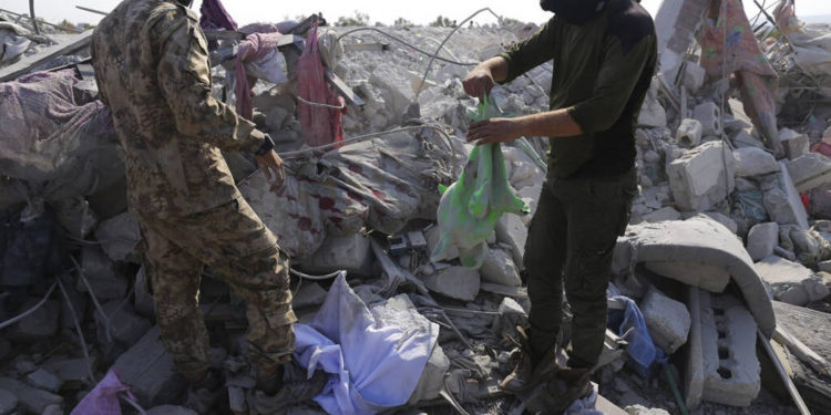 La gente mira una casa destruida cerca de la aldea de Barisha, en la provincia de Idlib, Siria, el 27 de octubre, luego de una operación del ejército estadounidense que atacó a Abu Bakr al-Baghdadi, el líder en la sombra del grupo Estado Islámico | Foto: AP / Ghaith Alsayed