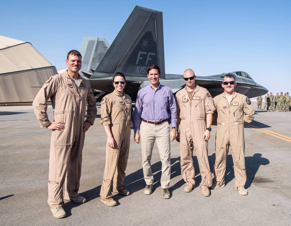 El secretario de Defensa Mark Esper, con la camisa azul, se encuentra con los aviadores frente a un F-22 Raptor en la Base Aérea Prince Sultan a principios de octubre.