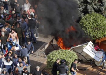Los partidarios de Hezbolá, a la izquierda, queman tiendas de campaña en el campamento de protesta establecido por manifestantes antigubernamentales cerca del palacio de gobierno, en Beirut, Líbano, el 29 de octubre de 2019 (Foto AP / Hussein Malla)