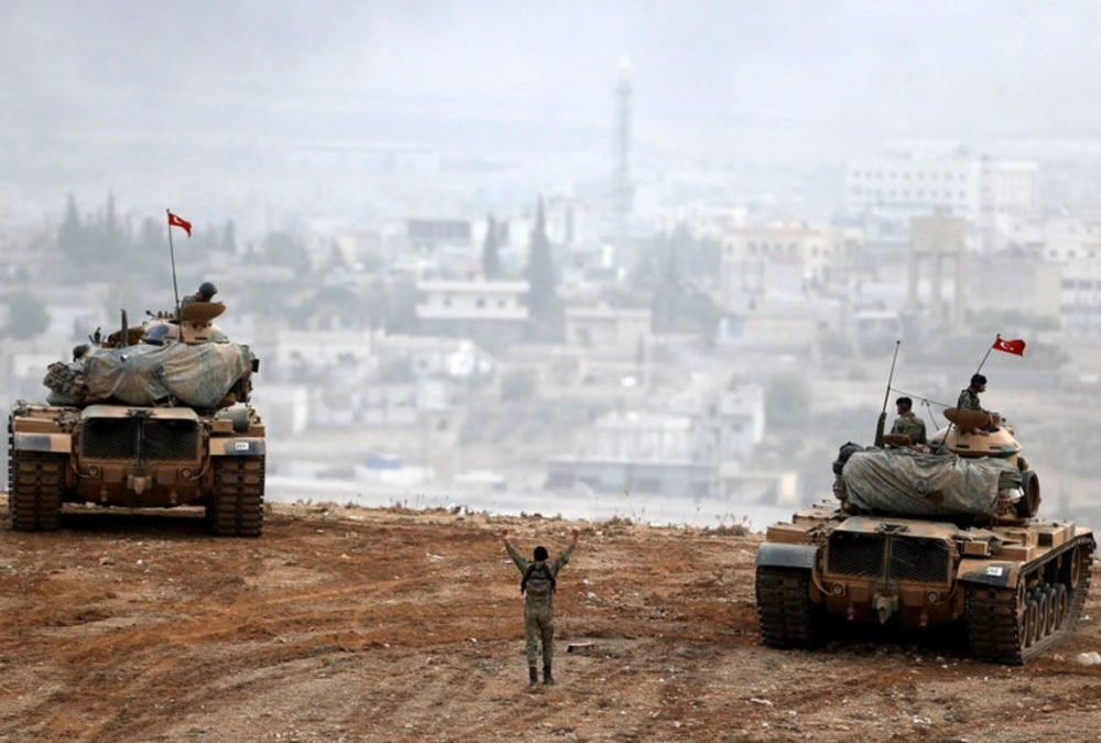 Los tanques del ejército turco maniobran mientras los kurdos turcos vigilan la ciudad siria de Kobani. (crédito de la foto: REUTERS)