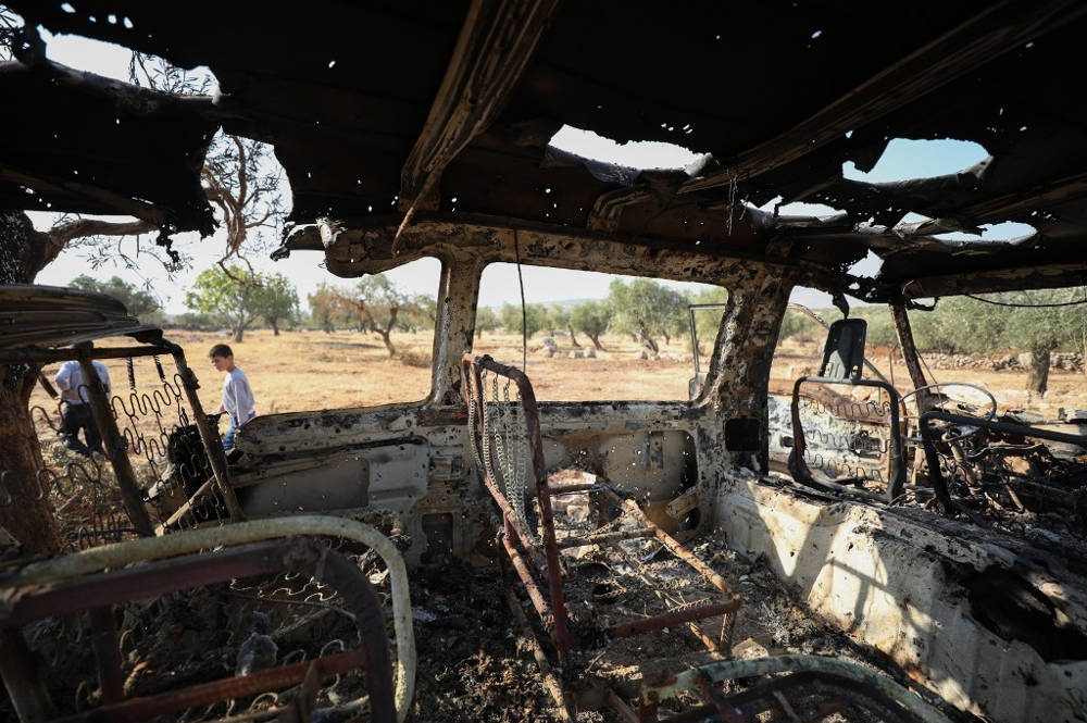 Una foto tomada el 27 de octubre de 2019 muestra un vehículo quemado cerca del sitio donde, según los informes, los disparos de helicópteros mataron a nueve personas cerca de la aldea de Barisha, en el noroeste de Siria, en la provincia de Idlib, cerca de la frontera con Turquía, donde 'grupos vinculados al grupo Estado Islámico' estuvieron presentes, según un monitor de guerra con base en Gran Bretaña con fuentes dentro de Siria (Omar HAJ KADOUR / AFP)