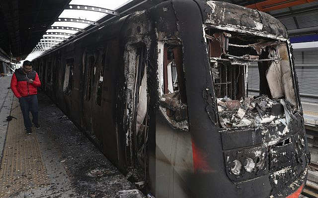 Los vagones del metro quemados por los manifestantes están estacionados en la estación Elisa Correa en Santiago, Chile, 20 de octubre de 2019. (Foto AP / Esteban Felix)