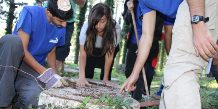 Estudiantes israelíes de la Asociación Ayalim arreglan lápidas olvidadas en el cementerio judío de Ioannina en Grecia. (crédito de la foto: AYALIM)