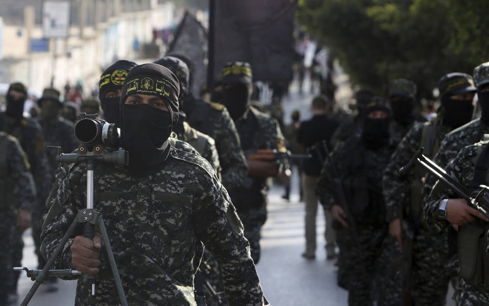 Miembros de las Brigadas Al-Quds, el ala militar del grupo terrorista Jihad Islámica, marchan con sus armas para mostrar lealtad al nuevo líder electo del movimiento palestino respaldado por Irán, Ziad al-Nakhalah, durante un mitin en Gaza, el 4 de octubre de 2018. (Foto AP / Adel Hana)