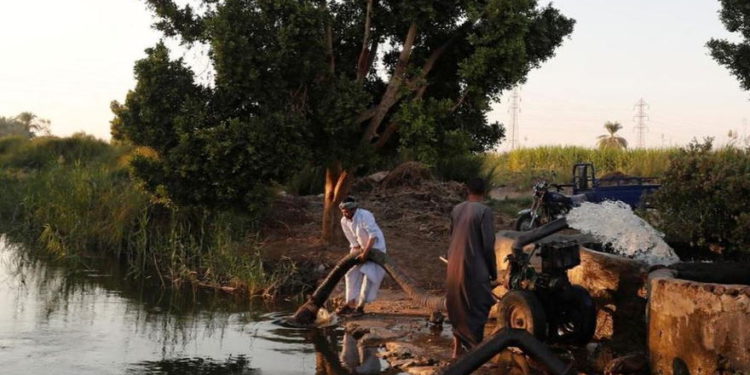 Los agricultores usan una máquina en un canal que desemboca en el río Nilo, al sur de Luxor