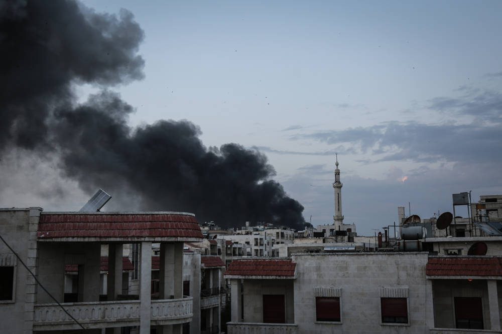 El humo sale de los edificios después de los ataques aéreos que se cree que fueron montados por aviones de combate rusos en áreas residenciales en el centro de la ciudad de Idlib, Siria, el 13 de marzo de 2019. (Anas Alkharboutli / Picture Alliance a través de Getty Images)