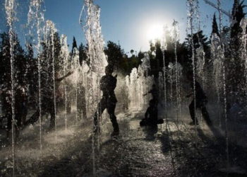 Los niños juegan en una fuente de agua en un caluroso día de verano cerca de la Torre de David en Jerusalén, 30 de julio de 2013. (Yonatan Sindel / Flash90)