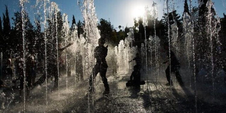 Los niños juegan en una fuente de agua en un caluroso día de verano cerca de la Torre de David en Jerusalén, 30 de julio de 2013. (Yonatan Sindel / Flash90)