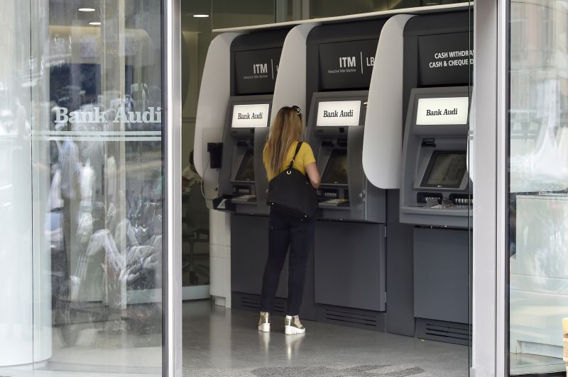 Las mujeres usan cajeros automáticos en el banco Blom en Beirut, Líbano, 1 de noviembre de 2019. Fotografía tomada a través del vidrio. REUTERS / Goran Tomasevic