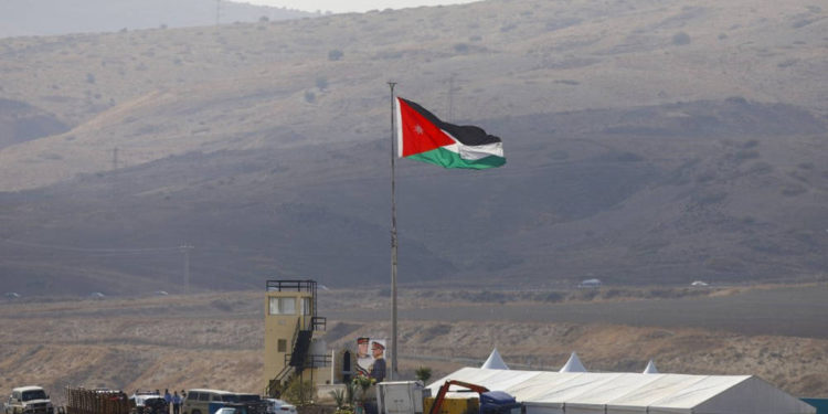 Una foto tomada desde el lado israelí de la frontera muestra a soldados jordanos izando la bandera nacional antes de una ceremonia en el sitio del Valle del Jordán de Naharayim, también conocido como Baqura en Jordania, al este del río Jordán el 10 de noviembre de 2019 (MENAHEM KAHANA / AFP)
