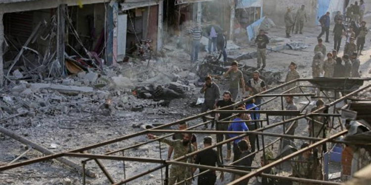 Combatientes sirios respaldados por Turquía inspeccionan el sitio de una explosión de coche bomba en la ciudad kurda de Tal Abyad, en el norte de Siria, en la frontera con Turquía, el 2 de noviembre de 2019. (Bakr Alkasem / AFP)