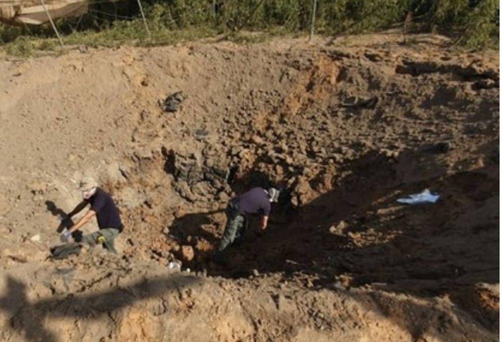 Los israelíes inspeccionan un cráter dejado por un nuevo cohete de la Jihad Islámica en el sur de Israel en noviembre de 2019 (Captura de pantalla / Canal 12)