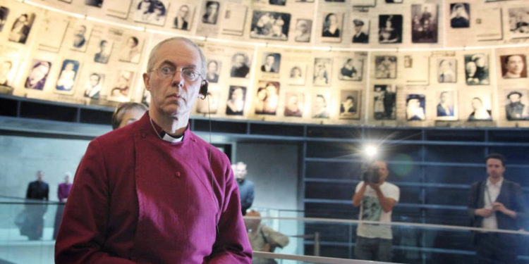 El actual arzobispo de Canterbury y obispo principal de la Iglesia de Inglaterra, Justin Welby, mira hacia arriba y a su alrededor fotografías de víctimas individuales del Holocausto en el Salón de los Nombres en el museo Memorial del Holocausto Yad Vashem en Jerusalén. 27 de junio de 2013. (Isaac Harari / FLASH90)