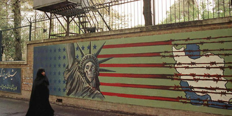 Una mujer iraní pasa junto a un mural antiestadounidense en la antigua embajada estadounidense en Teherán, el 3 de noviembre de 1999.