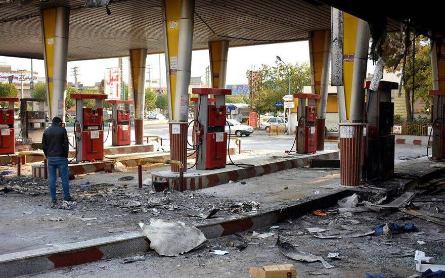 Un hombre iraní revisa una estación de gas quemada que fue incendiada por los manifestantes durante una manifestación contra un aumento en los precios de la gasolina en Eslamshahr, cerca de la capital iraní de Teherán, 17 de noviembre de 2019. (AFP)