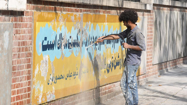 Un trabajador utiliza un limpiador de chorro de agua para borrar una pintura mural en la pared de la antigua embajada de EE. UU. En Teherán, 29 de septiembre de 2019