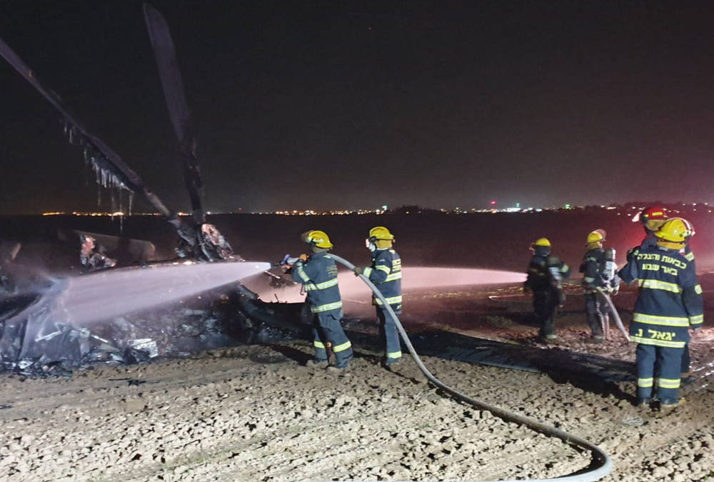 Los bomberos trabajan para extinguir un incendio en un helicóptero que realizó un aterrizaje de emergencia en un campo en las afueras de Rahat en el desierto de Negev el 26 de noviembre de 2019. (Servicios de bomberos y rescate)