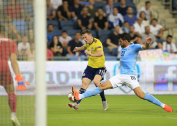 El escocés Callum McGregor dispara por el israelí Omri Ben Harush durante el partido de la Liga de Naciones en Haifa, Israel, el jueves 11 de octubre de 2018. (Foto AP / Ariel Schalit)