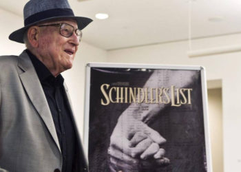 El sobreviviente croata de Auschwitz, Branko Lustig, se encuentra junto a un póster de la película La lista de Schindler en el memorial del Holocausto Yad Vashem en Jerusalén, 22 de julio de 2015. (Nir Elias / Pool Photo vía AP)