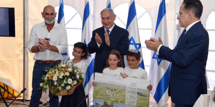 El presidente del Consejo Regional del Valle del Jordán, David Elhayani, el Primer Ministro Benjamin Netanyahu y el secretario del gabinete, Tzachi Braverman, aplauden después de que el gobierno autorizó la legalización del puesto avanzado de Mevo'ot Yericho en la reunión semanal del gabinete en el Consejo Regional del Valle del Jordán, el 15 de septiembre. 2019 (Haim Tzach / GPO)