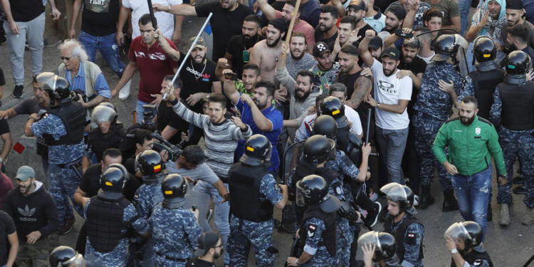 En esta foto de archivo del 29 de octubre de 2019, la policía antidisturbios intenta detener a los partidarios del grupo terrorista chií Hezbolá que llegan para quemar y destruir tiendas de campaña en el campamento establecido por manifestantes antigubernamentales cerca del palacio de gobierno, en Beirut, Líbano. (Foto AP / Hussein Malla, archivo)