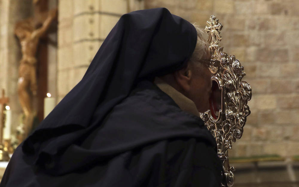 Una monja cristiana besa una reliquia de madera que se cree proviene del pesebre de Jesús en la iglesia de Notre Dame en Jerusalén, el viernes 29 de noviembre de 2019 (AP Photo / Mahmoud Illean)