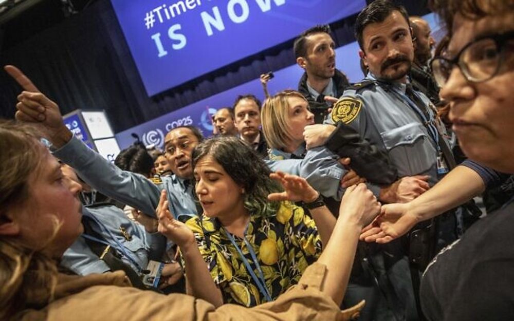 Los manifestantes se pelean con los miembros del personal de seguridad de la ONU durante una protesta en la cumbre COP25 en Madrid, 11 de diciembre de 2019. (Foto AP / Bernat Armangue)