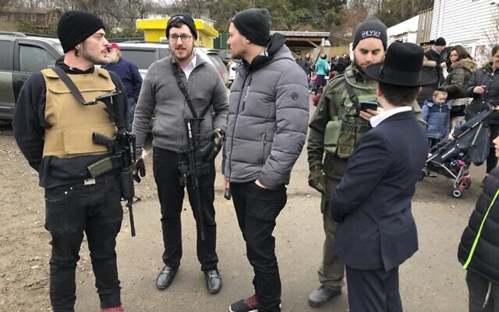 Miembros armados de la comunidad judía hacen guardia en una celebración, el domingo 29 de diciembre de 2019, en Monsey, Nueva York. Un día antes, un hombre que empuñaba un cuchillo irrumpió en la casa de un rabino y apuñaló a cinco personas mientras celebraban Hanukkah en el pueblo judío ortodoxo. comunidad. (Foto AP / Ted Shaffrey)