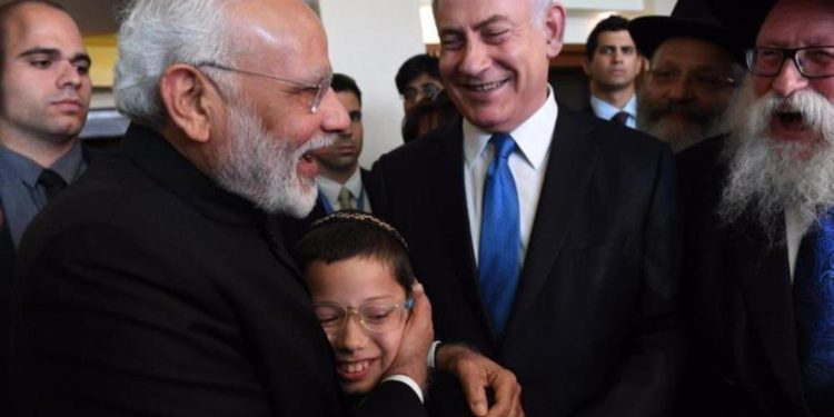 El primer ministro indio visitante Narendra Modi con la juventud israelí Moshe Holtzberg el 5 de julio de 2017. (Crédito de la foto: CHAIM TZACH / GPO)