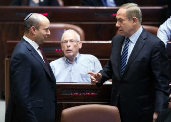 El primer ministro Benjamin Netanyahu, a la derecha, habla con el entonces ministro de Educación Naftali Bennett durante una sesión plenaria en la Knesset, el 5 de diciembre de 2016. (Yonatan Sindel/Flash90)