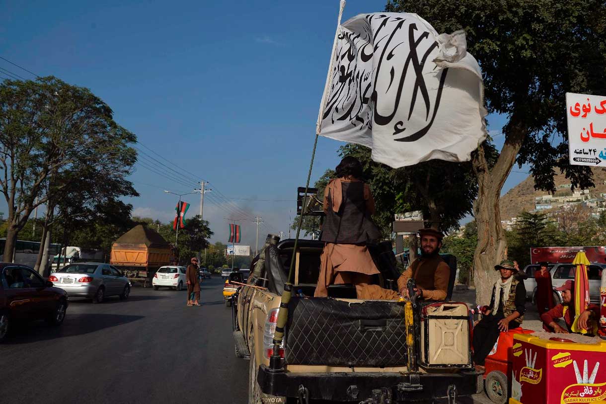 Islamistas talibanes viajan en un vehículo montado con la bandera talibán en la zona de Karte Mamorin, en la ciudad de Kabul, el 22 de agosto de 2021. (Foto de Hoshang Hashimi / AFP)