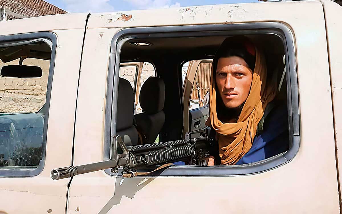 Un combatiente talibán sentado dentro de un vehículo del Ejército Nacional Afgano (ANA) al borde de la carretera en la provincia de Laghman el 15 de agosto de 2021. (AFP)