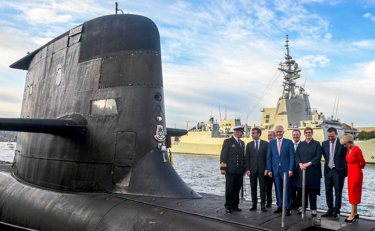 Una foto de archivo tomada el 2 de mayo de 2018 muestra al presidente francés Emmanuel Macron (2/L) y al primer ministro australiano Malcolm Turnbull (C) de pie en la cubierta del HMAS Waller, un submarino de clase Collins operado por la Royal Australian Navy, en Garden Island en Sídney. (Foto de BRENDAN ESPOSITO / POOL / AFP)