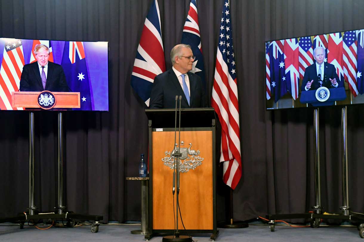 El primer ministro de Australia, Scott Morrison, en el centro, aparece en el escenario con enlaces de vídeo con el primer ministro de Gran Bretaña, Boris Johnson, a la izquierda, y el presidente de Estados Unidos, Joe Biden, en una conferencia de prensa conjunta en la Casa del Parlamento en Canberra, el jueves 16 de septiembre de 2021. Los líderes anuncian una alianza de seguridad que permitirá un mayor intercambio de capacidades de defensa, incluyendo la ayuda para equipar a Australia con submarinos de propulsión nuclear. (Mick Tsikas/AAP Image vía AP)