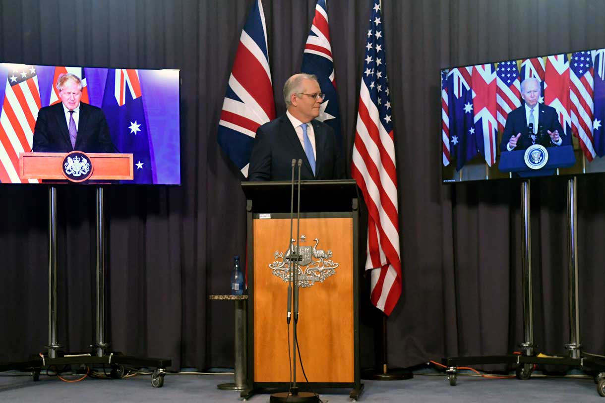 El primer ministro de Australia, Scott Morrison, en el centro, aparece en el escenario con enlaces de vídeo con el primer ministro de Gran Bretaña, Boris Johnson, a la izquierda, y el presidente de Estados Unidos, Joe Biden, en una conferencia de prensa conjunta en la Casa del Parlamento en Canberra, el 16 de septiembre de 2021. (Mick Tsikas/AAP Image vía AP)