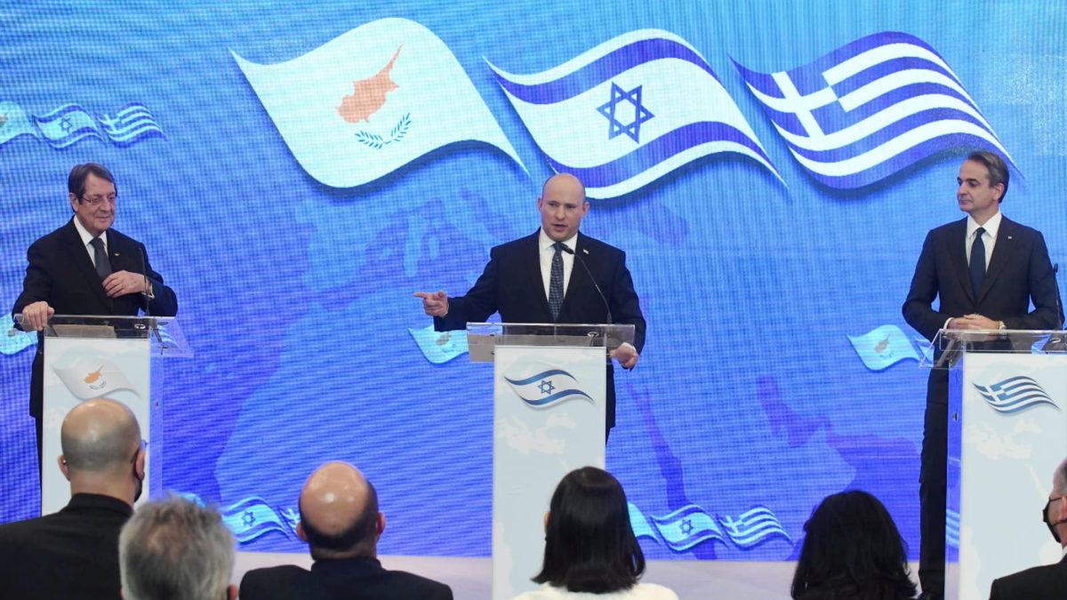 El primer ministro Naftali Bennett habla antes de la octava cumbre Grecia-Chipre-Israel junto al primer ministro griego Kyriakos Mitsotakis (izquierda) y el presidente chipriota Nicos Anastasiades, el 7 de diciembre de 2021. (Amos Ben Gershom/GPO)