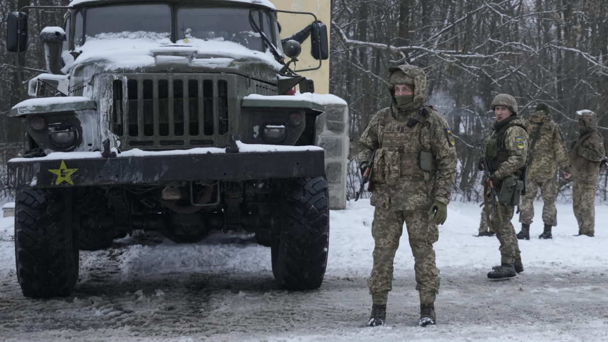 Militares ucranianos junto a un lanzacohetes militar ruso desactivado en las afueras de Kharkiv, Ucrania, el viernes 25 de febrero de 2022. Las tropas rusas se abalanzaron sobre la capital de Ucrania el viernes, con disparos y explosiones que resonaban cada vez más cerca del barrio gubernamental, en una invasión de un país democrático que ha alimentado los temores de una guerra más amplia en Europa y ha desencadenado los esfuerzos mundiales para hacer que Rusia se detenga. (AP Photo/Vadim Ghirda)