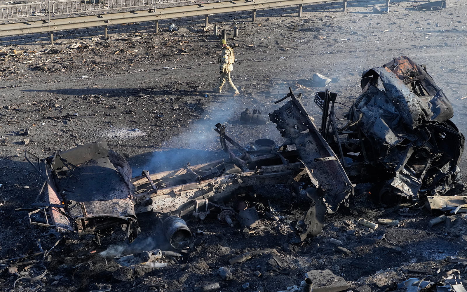 Un soldado ucraniano pasa junto a los restos de un camión militar en llamas, en una calle de Kiev, Ucrania, el 26 de febrero de 2022. (AP Photo/Efrem Lukatsky)