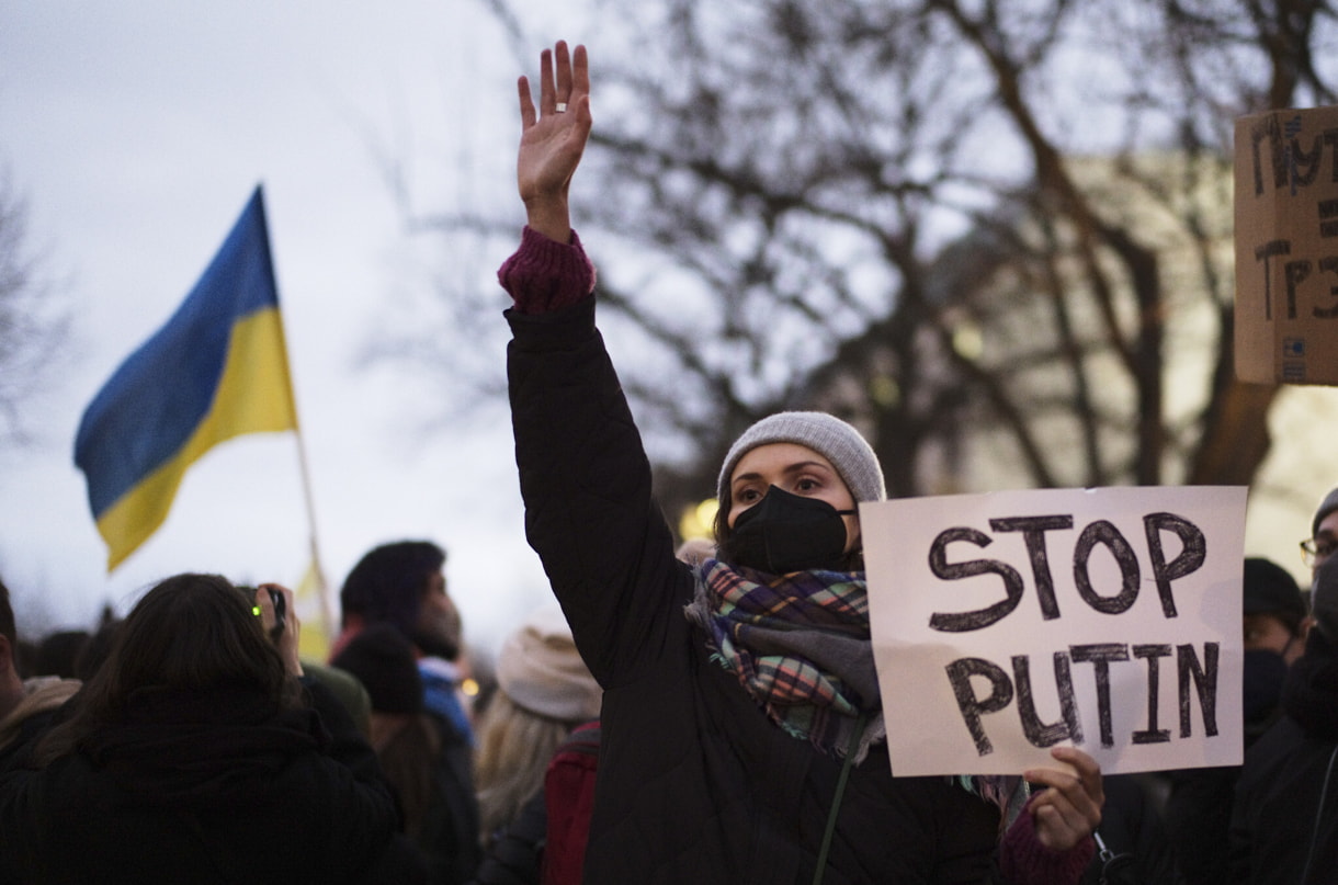 Una mujer muestra un cartel de apoyo a Ucrania en una manifestación a lo largo de la calle cerca de la embajada rusa para protestar contra la escalada de la tensión entre Rusia y Ucrania en Berlín, Alemania, el martes 22 de febrero de 2022. (AP Photo/Markus Schreiber)