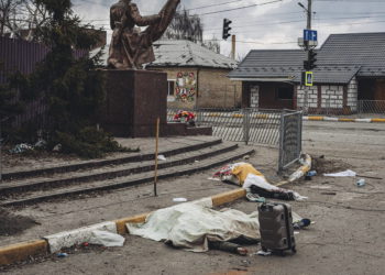 Los cadáveres de las personas muertas por los bombardeos rusos yacen cubiertos en la calle en la ciudad de Irpin, Ucrania, el 6 de marzo de 2022. (AP Photo/Diego Herrera Carcedo)