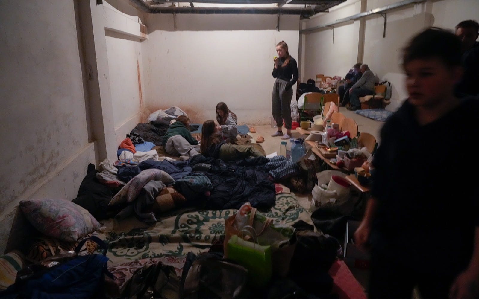 Unas personas se esconden de la artillería rusa en el sótano de una escuela en el pueblo de Horenka, cerca de Kiev, Ucrania, el 6 de marzo de 2022. (AP Photo/Efrem Lukatsky)