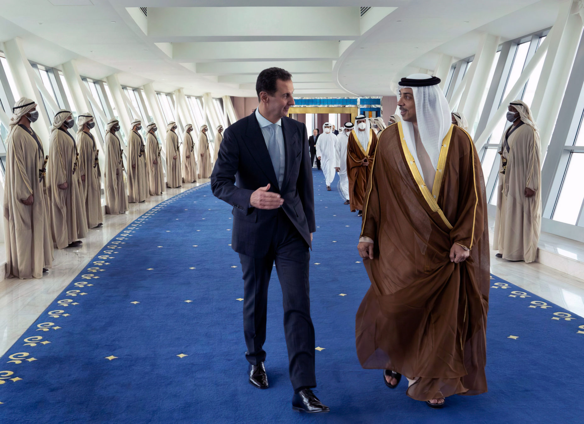 En esta foto publicada por la página oficial de Facebook de la Presidencia siria, el presidente sirio Bashar Assad, a la izquierda, habla con Mansour bin Zayed Al Nahyan, viceprimer ministro y ministro de Asuntos Presidenciales de los Emiratos Árabes Unidos, en Dubai, Emiratos Árabes Unidos, el viernes 18 de marzo de 2022 (página de Facebook de la Presidencia siria vía AP)