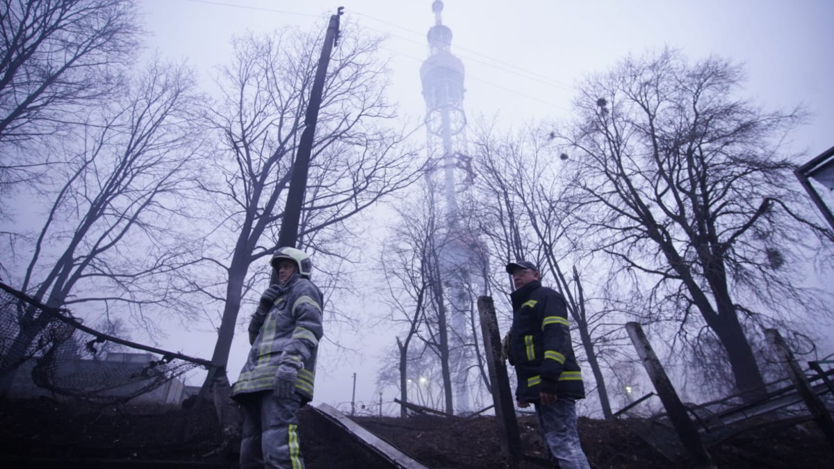 Bomberos ucranianos bajo una torre de transmisión de televisión en el cementerio judío situado en el sitio conmemorativo del Holocausto Babi Yar de Kiev el 1 de marzo de 2022. (Servicio Estatal de Emergencias de Ucrania)