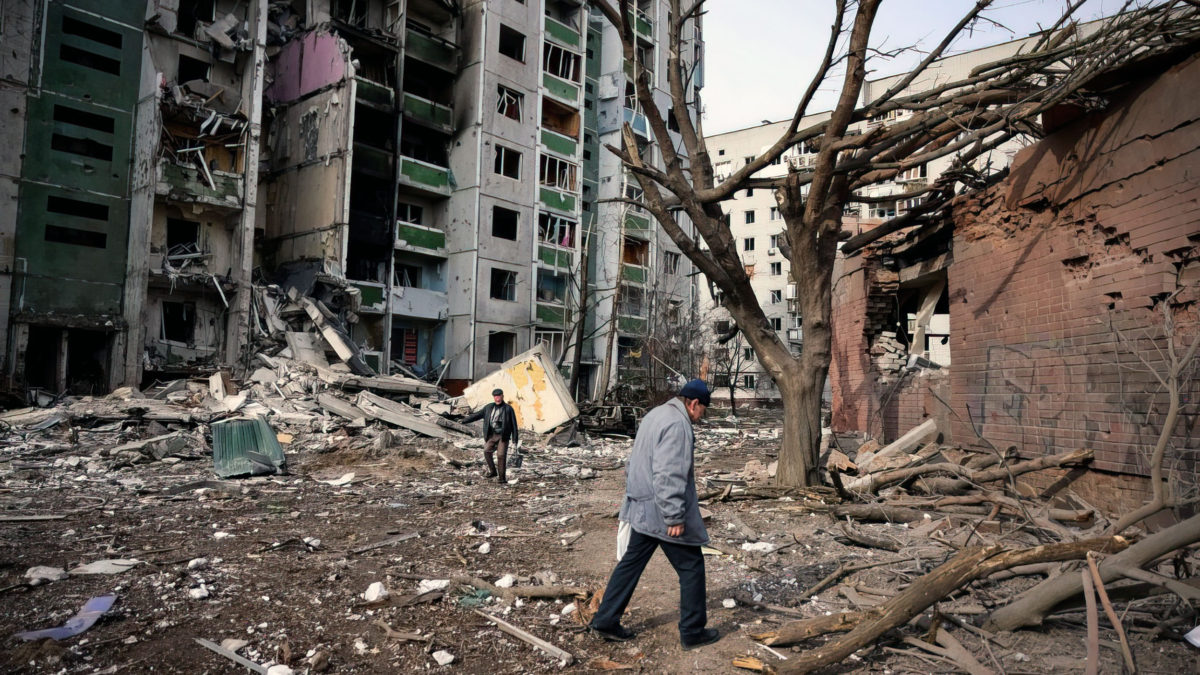 Unos hombres pasan por delante de un edificio residencial dañado en el bombardeo de ayer en la ciudad de Chernihiv, el 4 de marzo de 2022. (Dimitar Dilkoff/AFP)