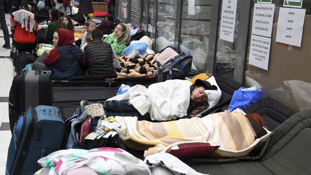 Personas descansan en un centro de acogida para desplazados de Ucrania en el paso fronterizo ucraniano-polaco de Korczowa, Polonia, el 5 de marzo de 2022. (Olivier Douliery, Pool Photo vía AP)