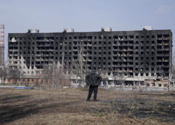 Un hombre observa un edificio de apartamentos quemado y dañado por los bombardeos en Mariupol, Ucrania, el domingo 13 de marzo de 2022. (AP/Evgeniy Maloletka)