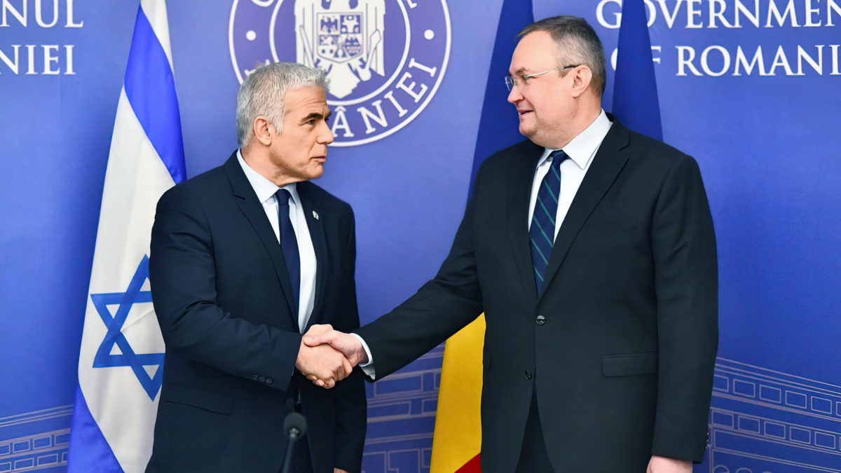 El ministro de Asuntos Exteriores Yair Lapid se reúne con el primer ministro rumano Nicolae Ciucă en Bucarest, el 13 de marzo de 2022 (Shlomi Amsalem/GPO)